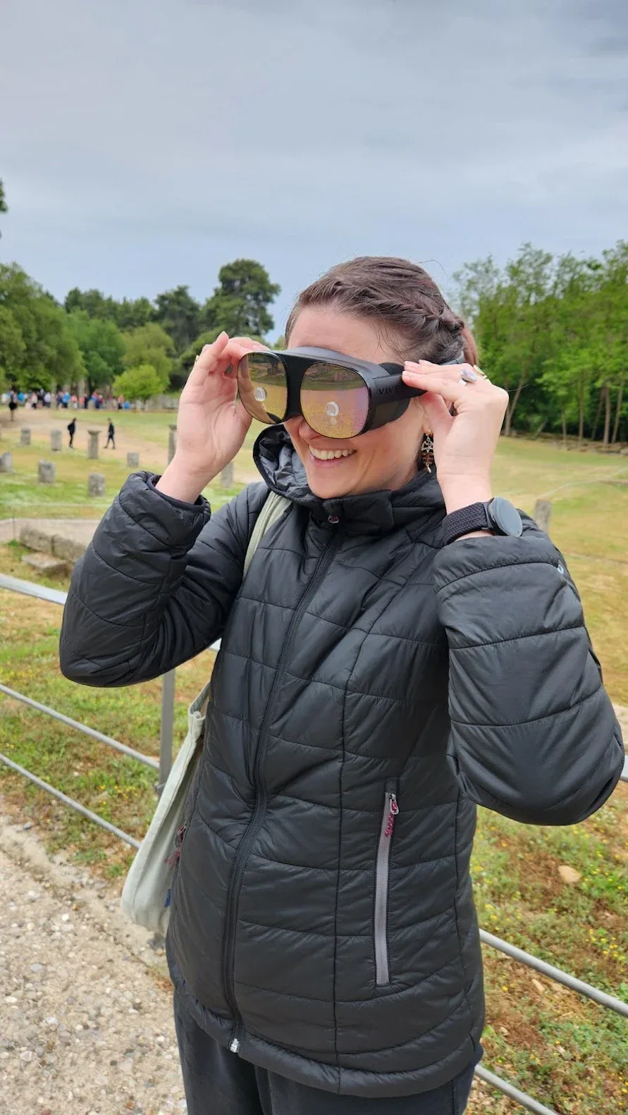 A smiling visitor putting on the VR glasses in Olympia